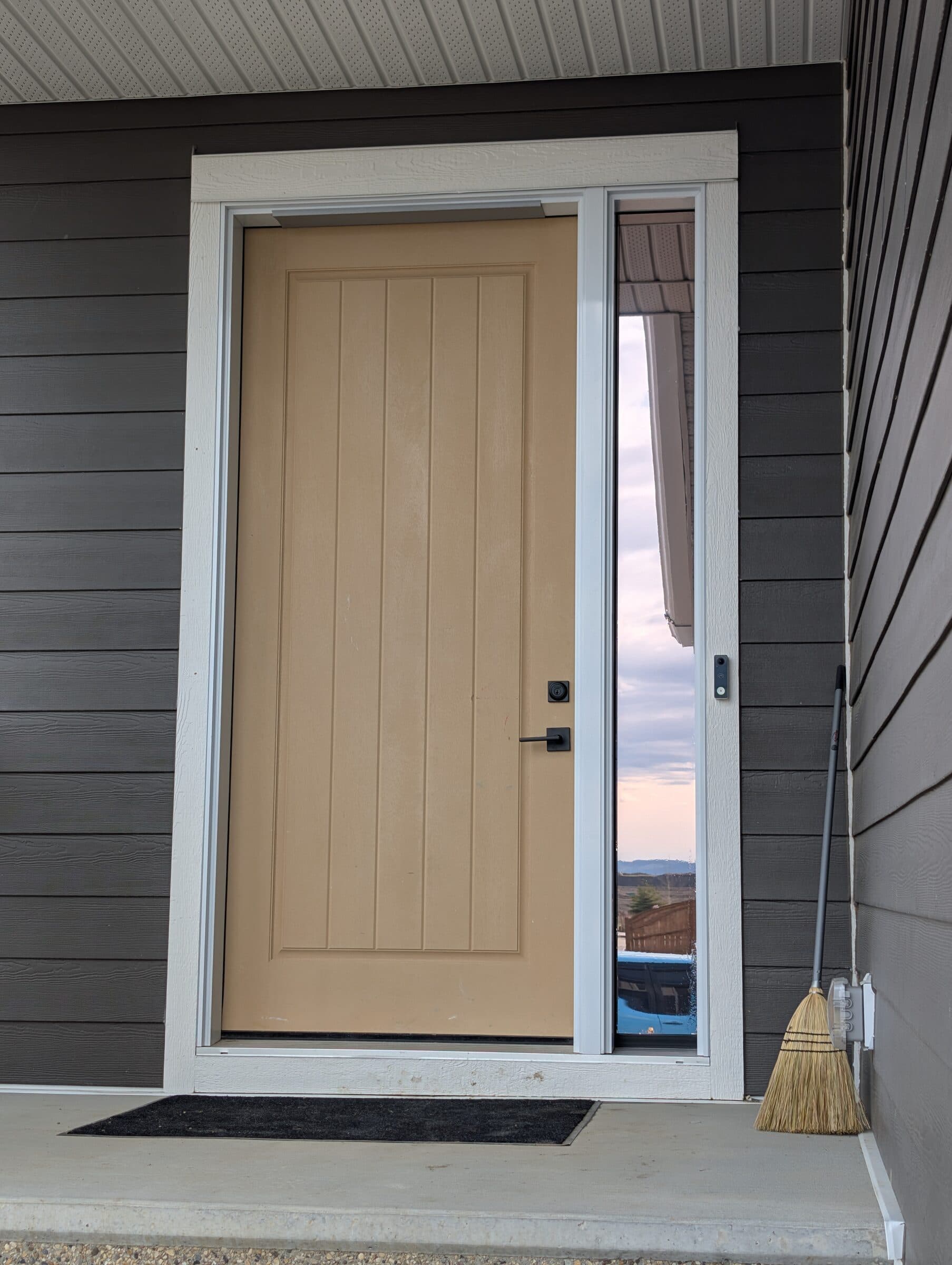 Front entry sidelite glass with combined solar and security window film in Harmony, Rocky View County