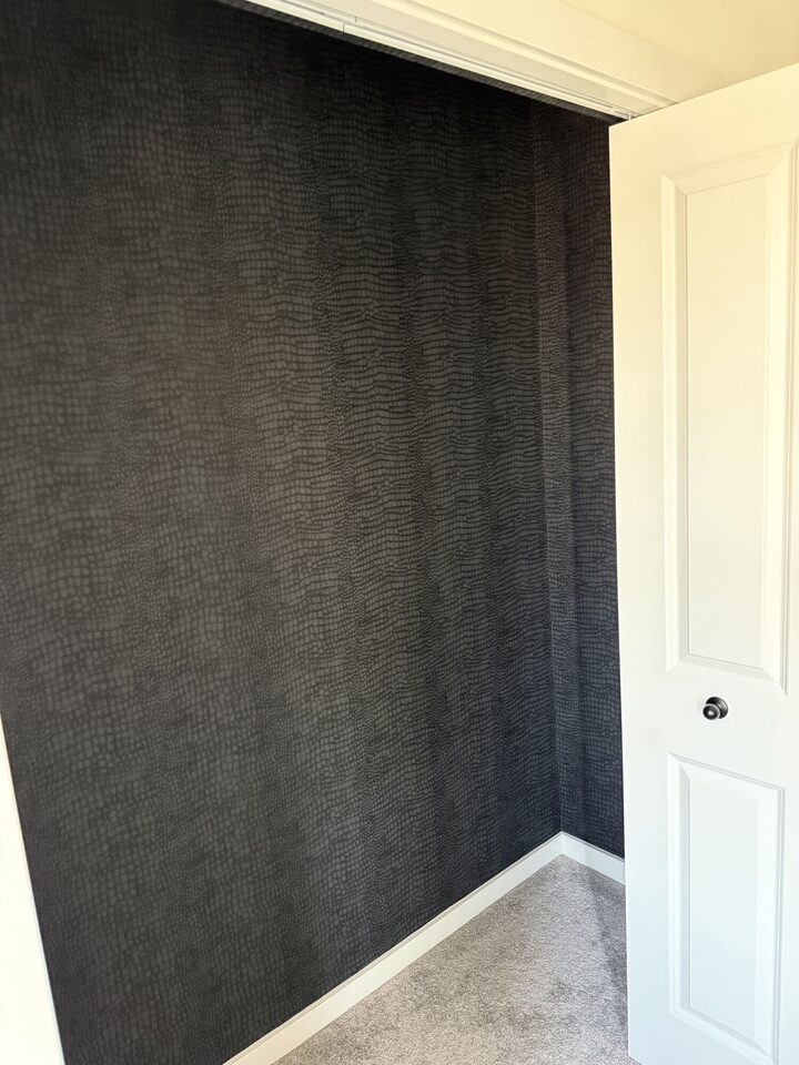 Finished inside corner where crocodile-texture wallpaper meets baseboard and door casing, Heritage Hills, Cochrane