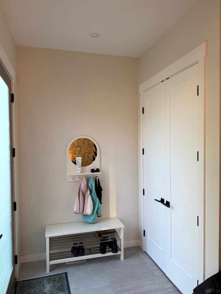 Altadore, Calgary front entry before wallpaper, a plain painted end wall with a bench and coat hooks