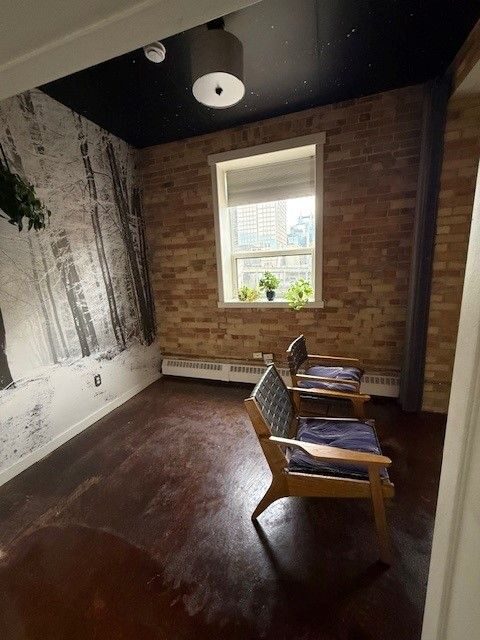 Lewis Lofts loft in Calgary's Beltline before removal: snowy-forest wall mural beside exposed brick under a dark star-pattern ceiling