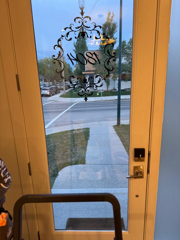 Before photo showing marked front entry door glass before frosted privacy window film replacement in Capitol Hill NW Calgary