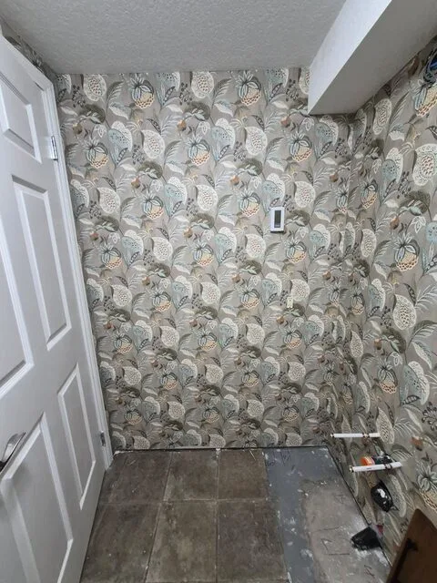 Botanical peel-and-stick wallpaper installed around a bathroom doorway in Chinook Park Calgary