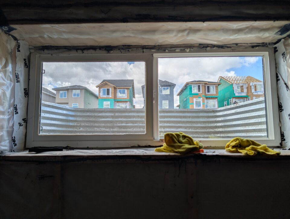 8 mil safety and security window film installed on a Cochrane new-build basement slider window