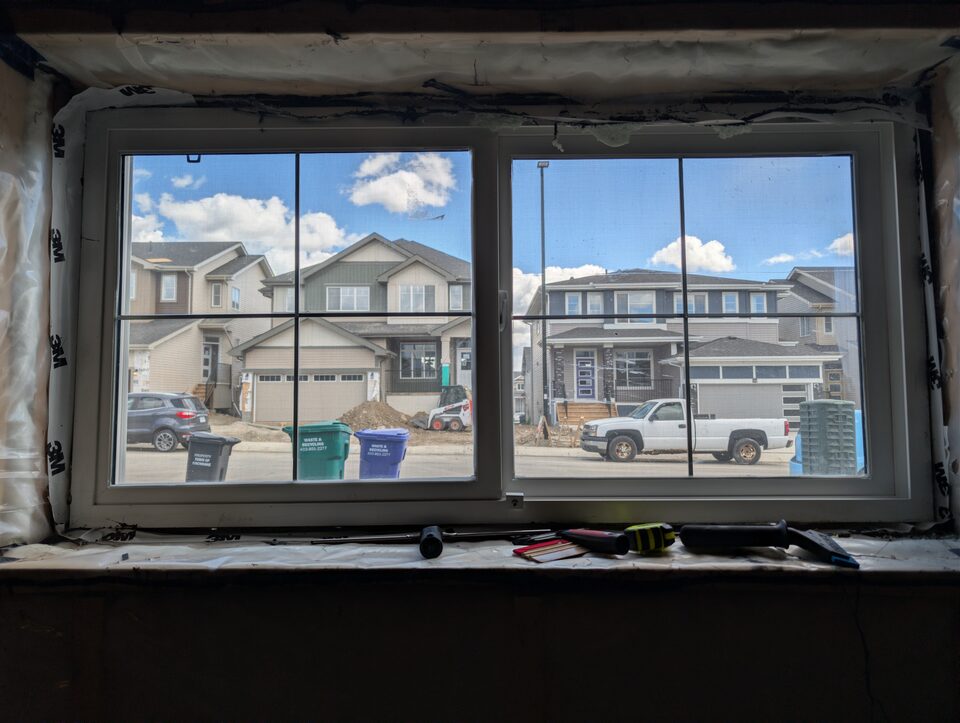 Second basement slider window with 8 mil safety and security window film in a Cochrane new-build home