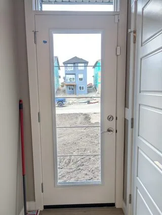 Case study for 8 mil safety and security window film on a Cochrane new-build home: basement sliders, front entry, and back door glazing kept
