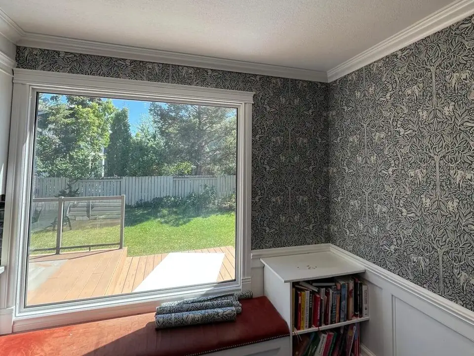 Black and white botanical wallpaper installed around a dining room window in Deer Run SE Calgary