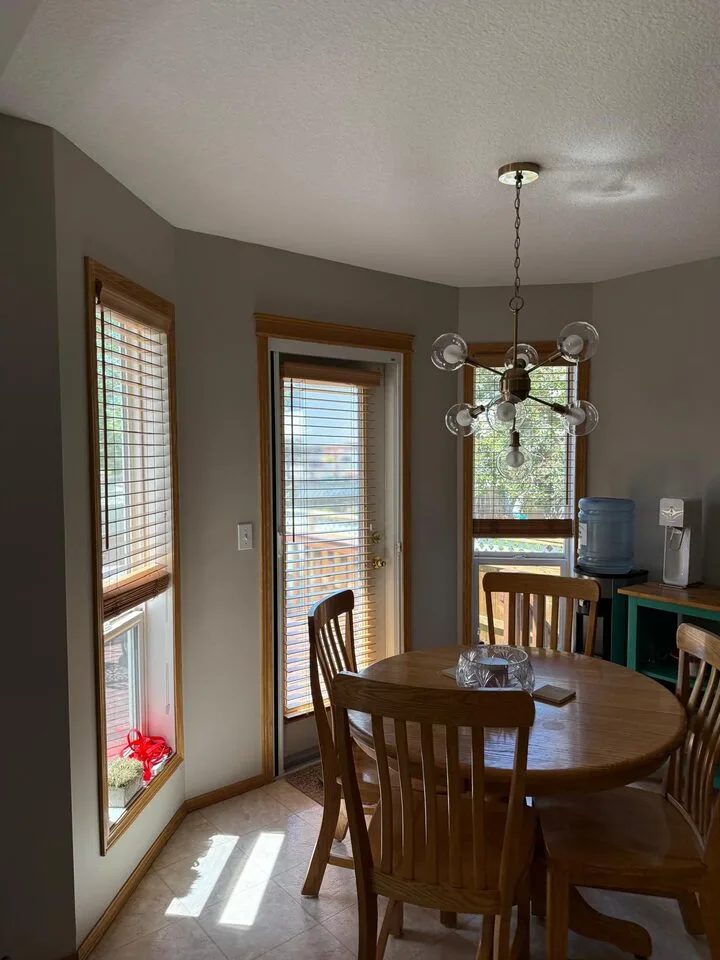 Dining area windows with aging failing solar film before replacement in Douglasdale SE Calgary