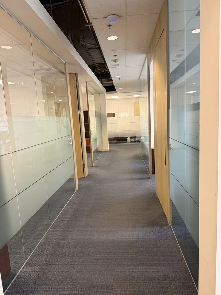Frosted privacy film on glass office partitions along a corridor in a downtown Calgary office tower