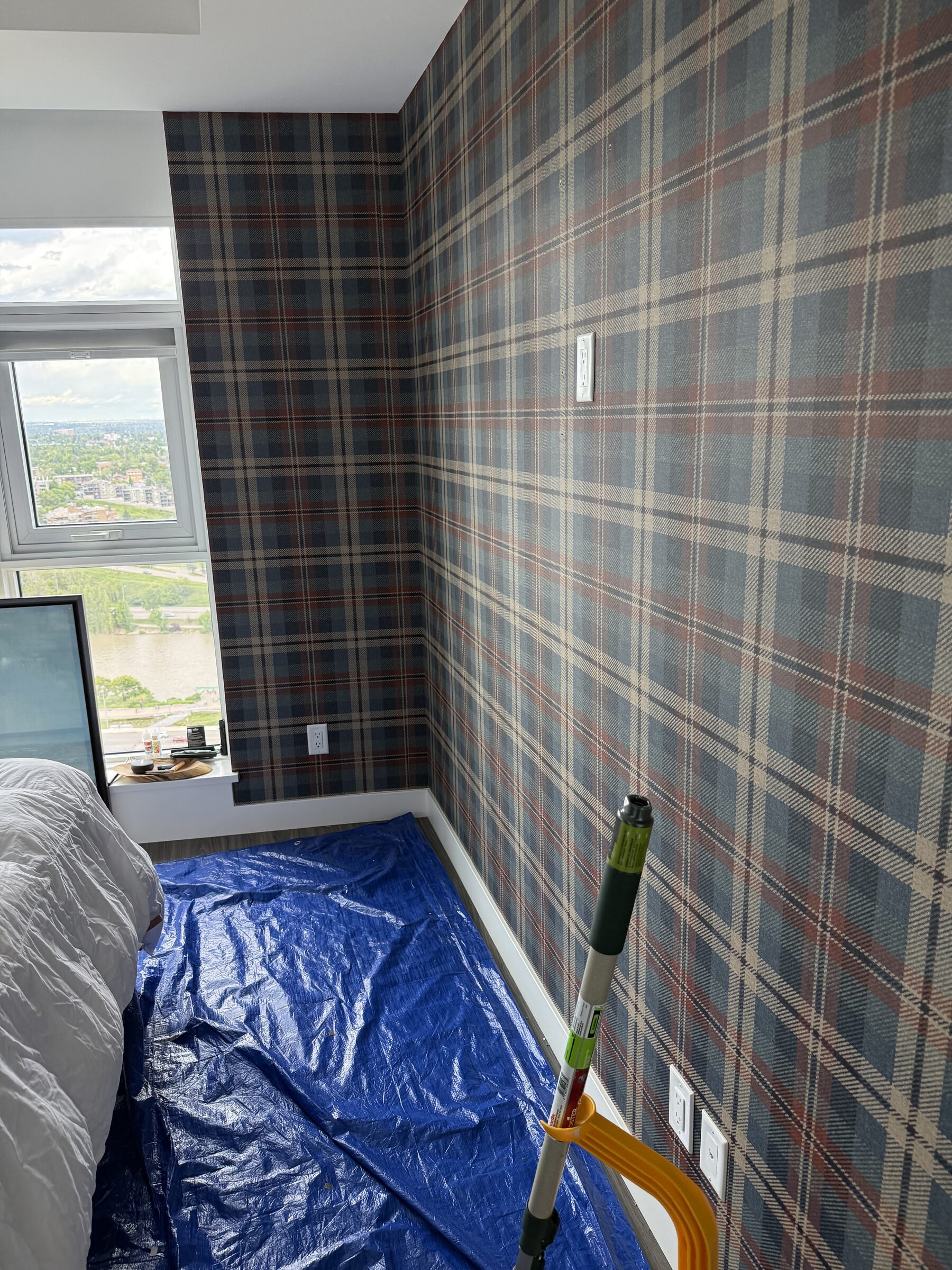 Finished tartan plaid wallcovering feature wall with pattern-matched seams in an East Village downtown Calgary condo bedroom