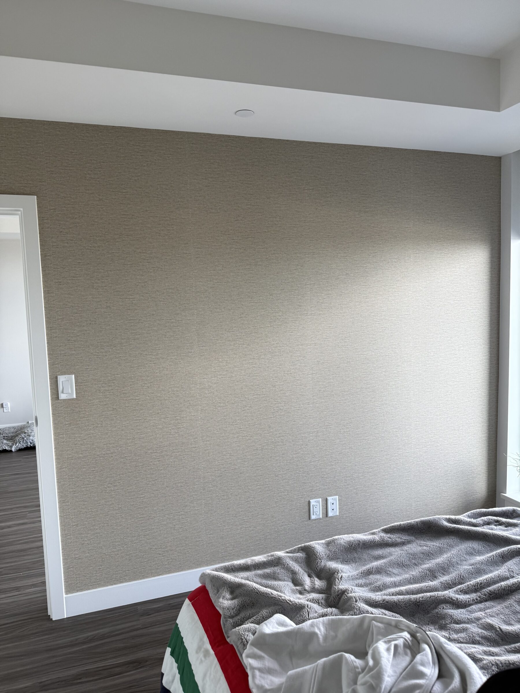 Finished woven linen-look Type II vinyl wallcovering on a condo bedroom wall in East Village Calgary