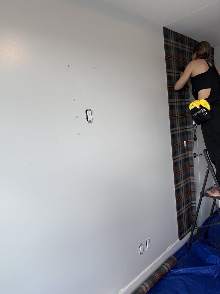 Installer preparing plaid wallcovering panels in an East Village Calgary condo