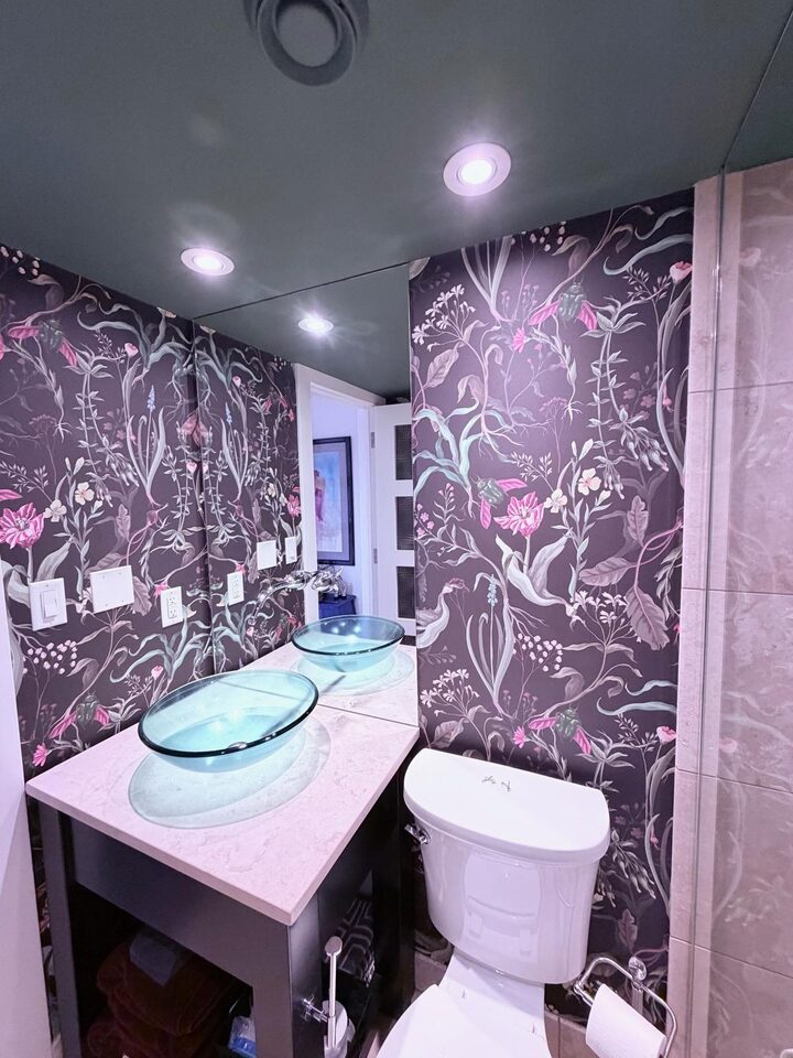 Night Garden dark botanical mural wallpaper and a deep green painted ceiling in an Eau Claire condo bathroom, Calgary