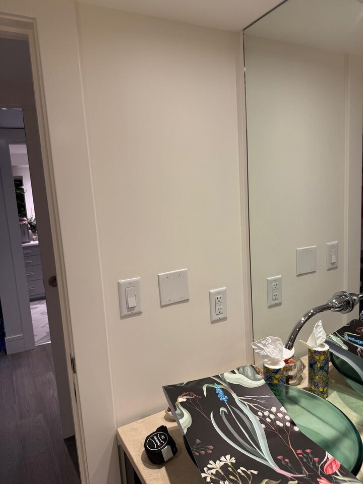 Eau Claire, Calgary condo bathroom vanity wall before the mural, with switch plates and the mural roll waiting on the counter