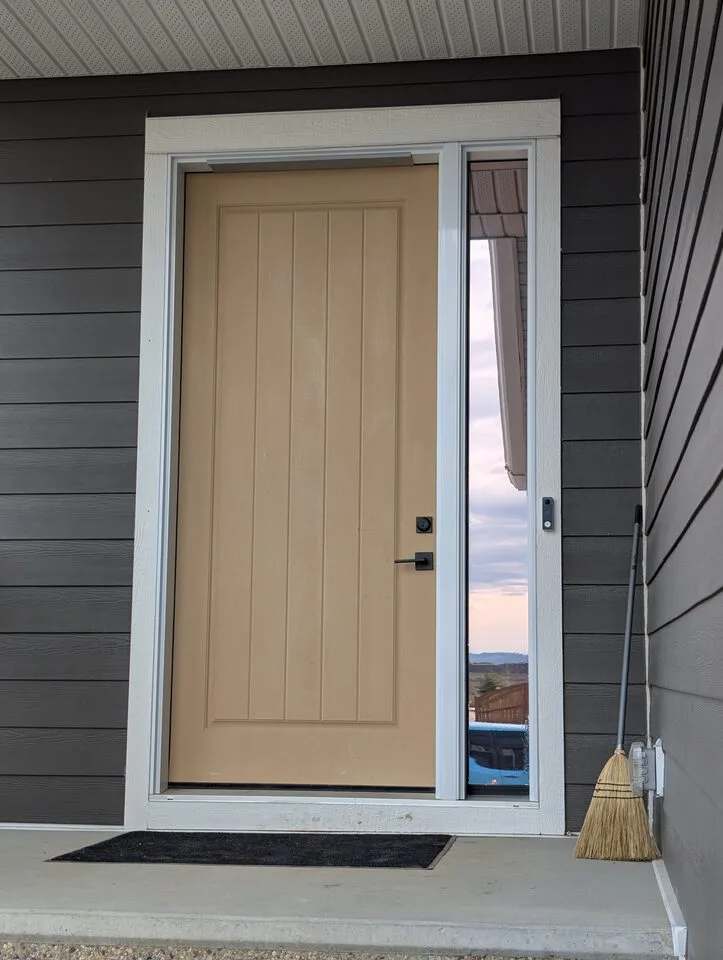 Front entry sidelite glass with combined solar and security window film in Harmony, Rocky View County