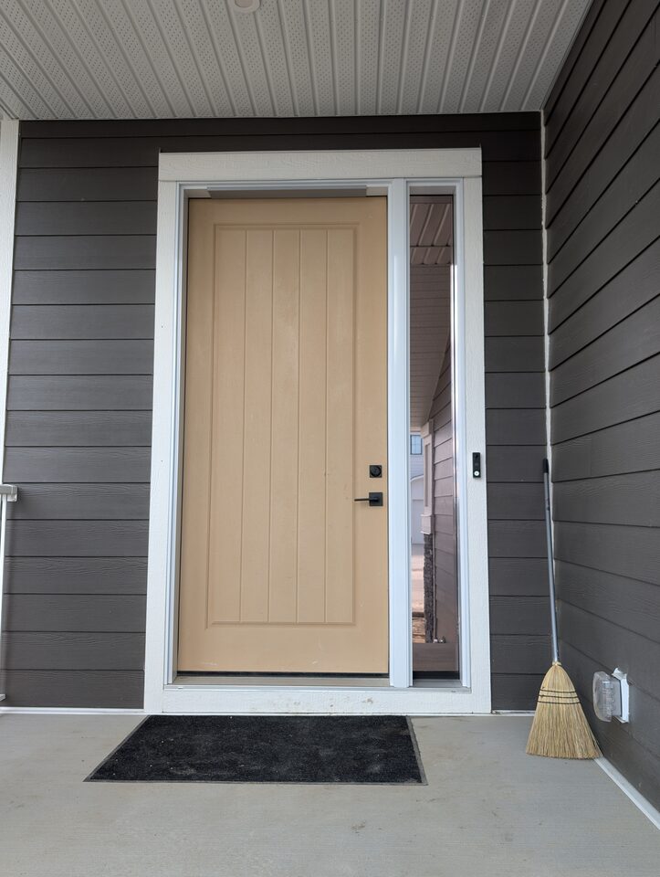 Full front entry view after solar and security window film installation on a sidelite in Harmony Rocky View County
