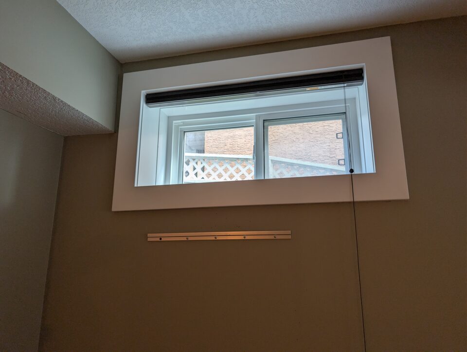 Before wide interior photo of a basement window before solar and security window film installation in Harmony Rocky View County