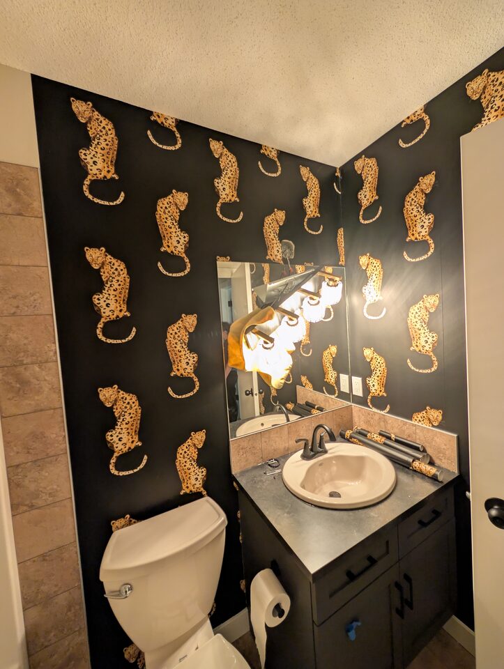 Full room view after peel-and-stick leopard wallpaper installation in McKenzie Towne Calgary