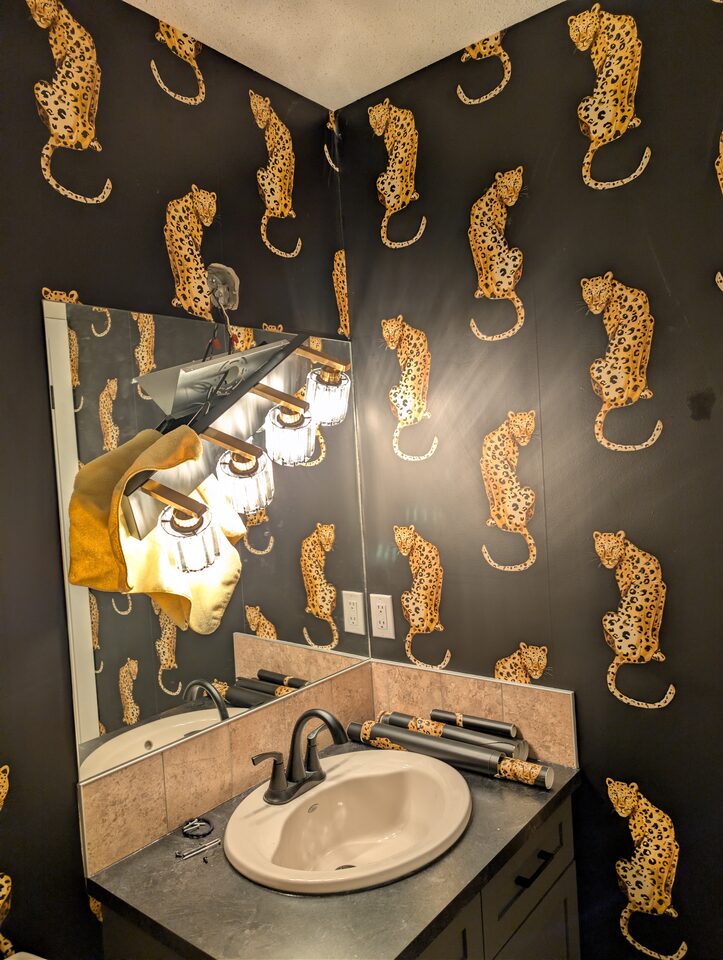 Vanity wall after peel-and-stick leopard wallpaper installation in a McKenzie Towne Calgary powder room