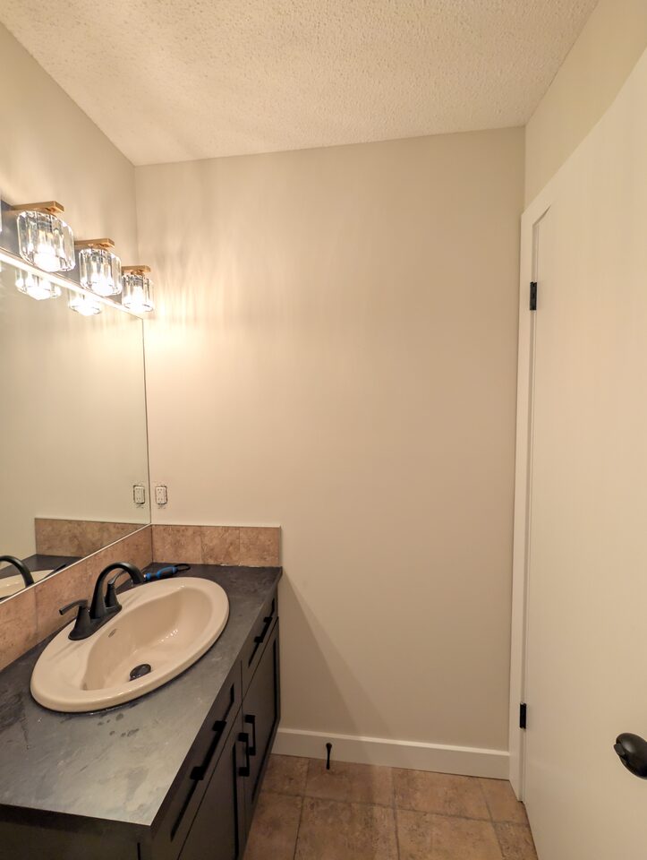 Before photo of the side wall in a McKenzie Towne Calgary powder room before peel-and-stick wallpaper installation
