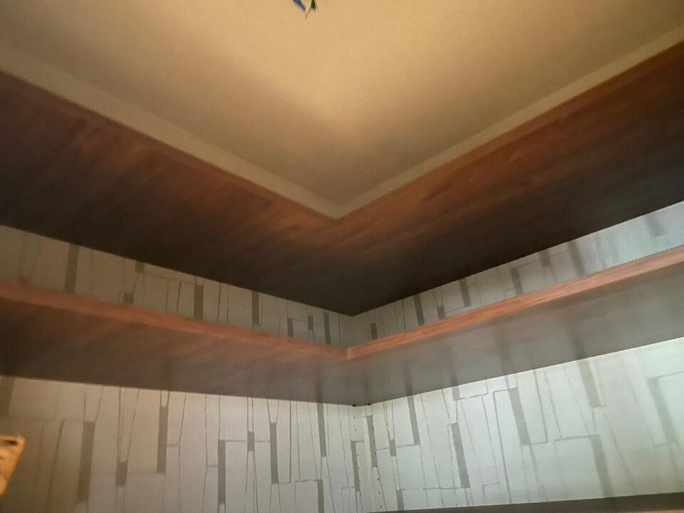 Geometric pattern wallpaper installed around built-in wood pantry shelves in Shaganappi SW Calgary