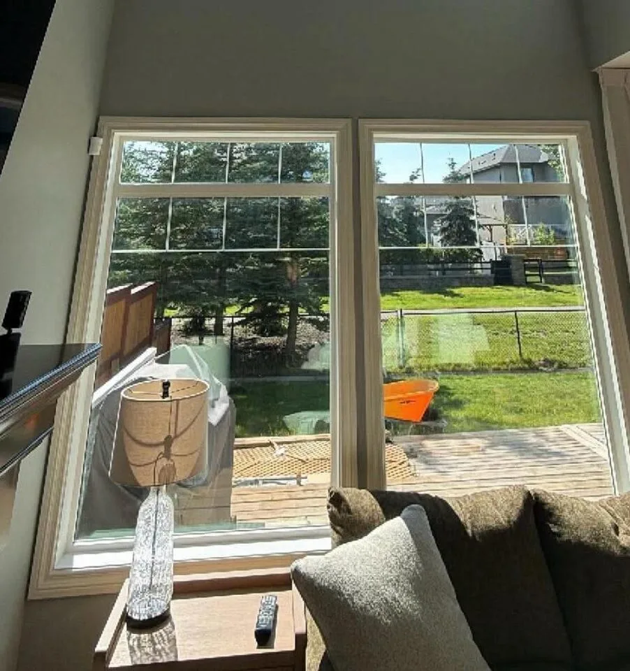 Two-storey great room with XPEL Night Vision 37 solar window film on tall backyard-facing windows in Silverado SW Calgary