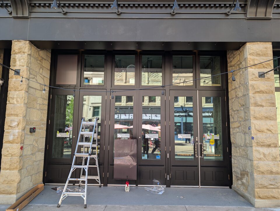Access ladder beside the glazed storefront during the Downtown Calgary solar-film installation