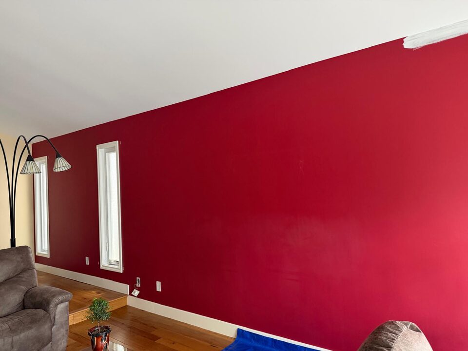 Before photo of a red living room feature wall before mural wallpaper installation in Sundance SE Calgary