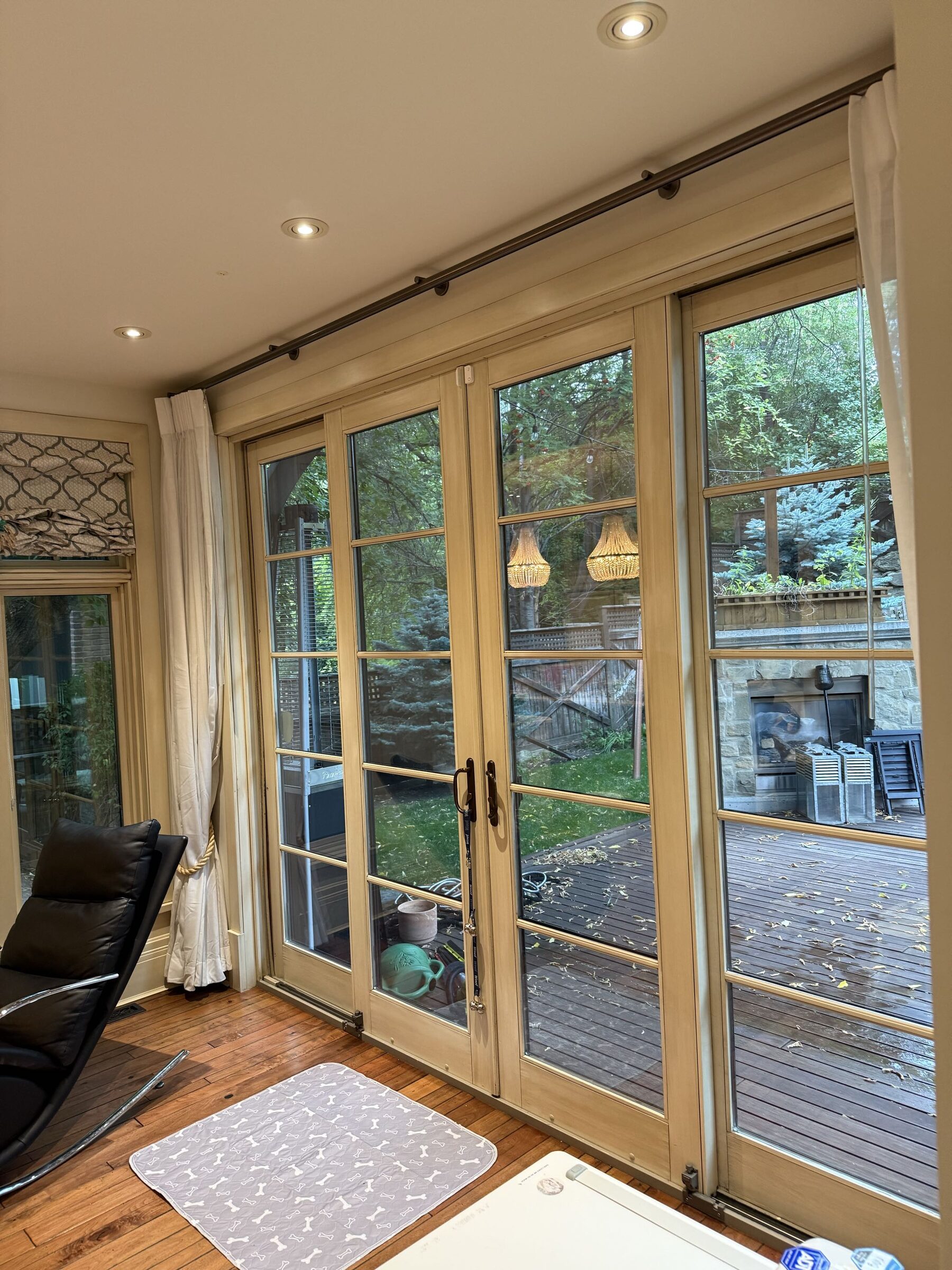Glazed patio doors and adjacent panels photographed at the Upper Mount Royal security-film project. The landscaped deck is visible through the glass.